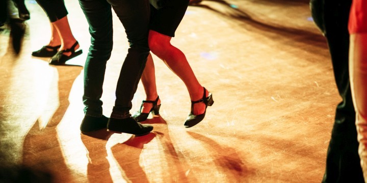 Füße eines tanzenden Paares auf Parkettboden