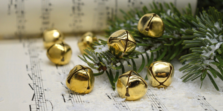 Ein Tannenzweig und Glöckchen liegen auf Notenblättern.  ©Pixabay